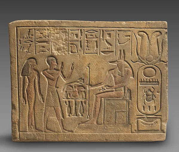 Relief showing a priest and a woman worshipping Anubis