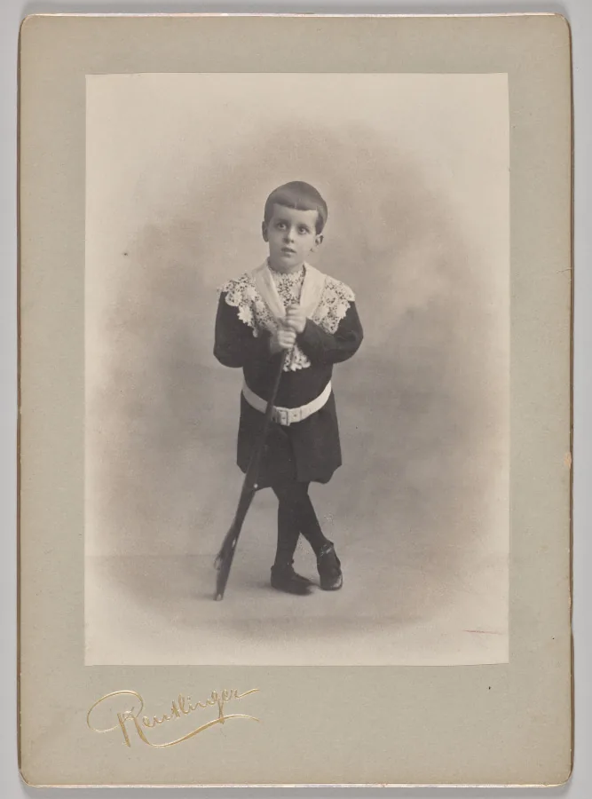 Untitled (young boy with lace collar and toy rifle)